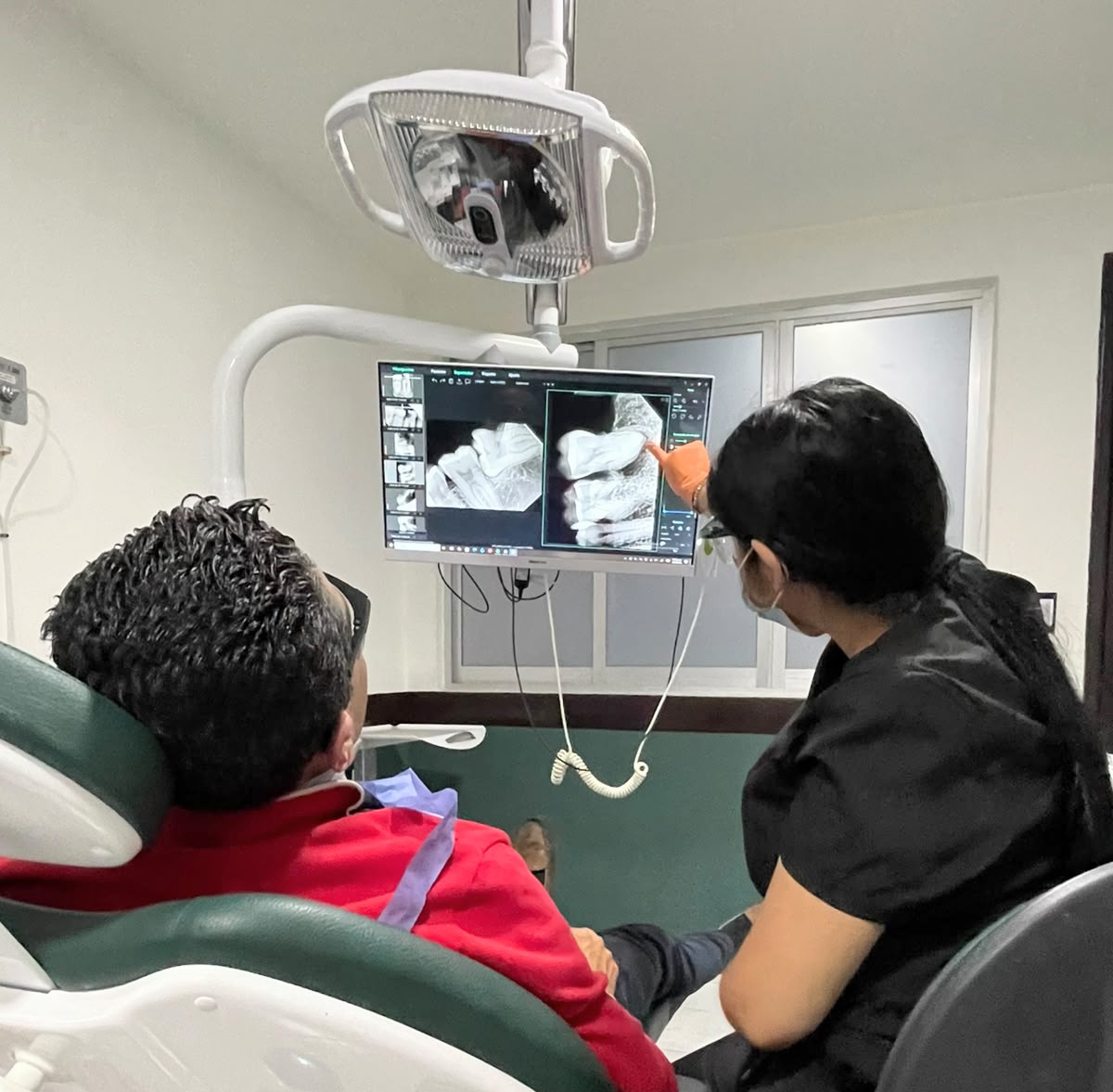 Doctora explicando una radiografía a un paciente en la clínica